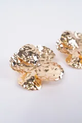 Par de caravanas con diseño de flor de cinco pétalos, con acabado metálico plateado y textura irregular martillada.