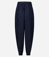 Pantalón de jean estilo aladín con cintura alta y pretina estructurada. Presenta pinzas frontales, volumen en la cadera y piernas con entalle progresivo que finalizan en puños con elástico, logrando un efecto jogger sofisticado.