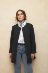 Tapado largo color crema, de paño, con cuello a la base y botones redondos veteados.