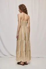 Vestido largo negro de algodón, con breteles finos, escote con frunce y lazo regulable. Tiene cintura definida y falda amplia escalonada, con detalles bordados verticales en contraste.