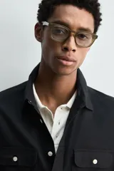 Sobrecamisa de corte relajado confeccionada en tejido ligero de algodón color negro. Presenta cuello de solapa, manga larga con puños abotonados y dos bolsillos de plastrón con solapa en el pecho. Cuenta con cierre frontal de botones a contraste y aberturas laterales en el bajo.