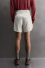 Short deportivo de trail running confeccionado en tejido técnico elástico con textura. Presenta una cintura elástica ancha con compartimentos integrados, bolsillo trasero con cierre y aberturas laterales en el bajo.