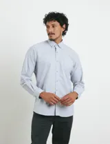 Camisa de tejido Oxford con cuello button-down, manga larga y bolsillo frontal. Presenta botones al tono y un corte clásico.