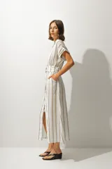 Vestido camisero midi a rayas verticales color blanco y beige, con cuello camisero, mangas cortas con dobladillo, cierre frontal con botones y cinturón con hebilla forrada.