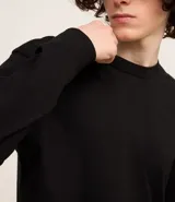 Remera de manga larga con cuello redondo, confeccionada en algodón. Presenta un corte comfort holgado y una pequeña etiqueta decorativa en el bajo.