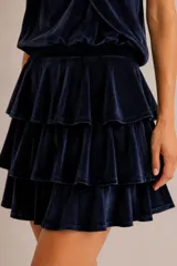 Minifalda azul marino de terciopelo con diseño de múltiples volantes en capas.