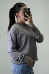 Buzo de cuello redondo con efecto acid wash, de corte holgado y mangas largas con puños elásticos.