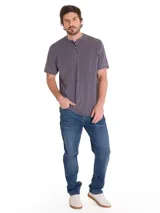Jeans de denim azul con calce slim, diseño clásico de cinco bolsillos, cierre de cremallera y botón, y costuras en contraste.