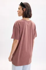 Remera oversize de manga corta color marrón con efecto gastado, con gran estampa frontal de Mickey y Minnie Mouse y tipografía retro.