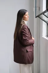 Blazer de corte sastrero en color marrón chocolate, con solapas clásicas, bolsillos delanteros con solapa y costuras a la vista en tono contrastante.