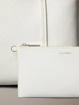 Cartera tote pequeña de Calvin Klein color blanco con estampado de monograma CK en toda la superficie, asas de hombro dobles y diseño estructurado. Incluye una cartera mini interior a juego con cierre y logo de la marca.
