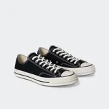 Zapatillas Converse Chuck 70 OX de lona negra con cordones blancos y suela de goma color crema.