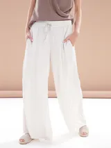 Pantalón palazzo blanco con cintura alta y cordón ajustable.