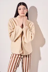 Campera beige de corderito vegano con cuello mao y cierre frontal con botones a presión.