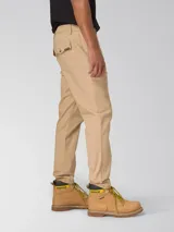 Pantalón chino beige de corte slim tapered, con bolsillos laterales y traseros, cierre de cremallera y botón, y tejido elástico.