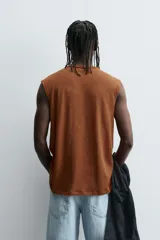 Camiseta sin mangas (tank top) de corte relajado, color marrón óxido, con cuello redondo y sisa ancha.