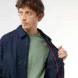 Campera tipo bomber azul marino de twill, con cierre frontal, bolsillos laterales, cuello camisero y puños y cintura elastizados.