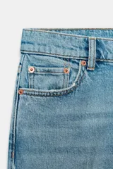 Jeans cropped flare de tiro medio color celeste, confeccionados en denim con efecto lavado. Presentan diseño de cinco bolsillos, trabillas para cinto, raya planchada al frente y bajo desflecado con terminación evasé. Cuenta con cierre frontal de cremallera y botón metálico.