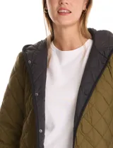 Campera reversible de corte largo con diseño capitoneado. Un lado presenta un tono verde oliva y el otro un tono negro, ambos con cierre frontal mediante botones a presión y bolsillos laterales.