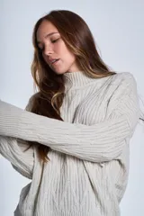 Sweater color crema con cuello alto y diseño de trenzas.