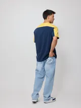 Remera negra de algodón con corte en hombros y mangas, cuello redondo gris oscuro y ribete blanco en los hombros. Estampado frontal con el texto "RUSTY" en tipografía futurista blanca con borde gris.