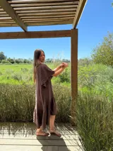 Vestido verde oliva de lino, corte suelto, con mangas abullonadas y volado en el ruedo.