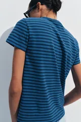 Camiseta de corte slim fit y diseño a rayas horizontales, con cuello redondo y mangas cortas.