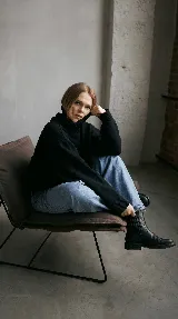 Bota corta tipo chelsea de cuero vacuno color negro, con elásticos laterales, taco cuadrado de madera y suela de caucho.