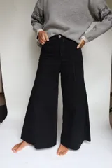 Pantalón de pierna ancha con tiro medio, confeccionado en brin de algodón con spandex. Presenta costuras a contratono y cierre frontal con botón.