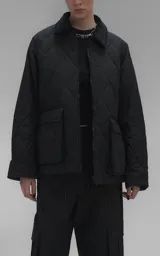 Campera oversize de microfibra opaca con diseño matelaseado de rombos. Presenta cuello de corderoy a tono, cierre frontal metálico y dos amplios bolsillos delanteros con solapa y broche snap. Interior forrado y relleno con guata térmica.