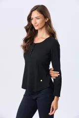 Remera lisa de algodón color blanco, con cuello redondo y botones a tono. Tiene manga larga y un ruedo curvo.