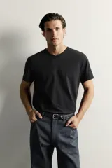Camiseta blanca de corte relajado, con cuello en V y mangas cortas.