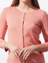 Cardigan blanco de tejido fino con abertura central y botones.