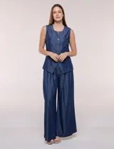 Chaleco de lyocell color azul, con escote redondo, sin mangas, cierre frontal con botones metálicos y bolsillos en la cintura.