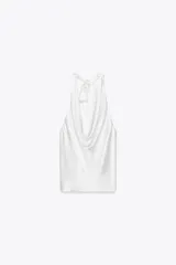 Top blanco de tejido satinado con cuello halter drapeado ajustable con lazada en el cuello y espalda descubierta con lazada.