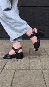 Sandalias de cuero combinadas en azul y negro, con diseño de textura croco en la capellada, costuras en contraste y taco ancho de madera. Poseen tira al tobillo con hebilla metálica regulable.