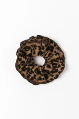 Gomita para el pelo tipo scrunchie con diseño de estampado animal print en tonos marrones y negros.