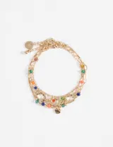 Set de tres pulseras doradas con dijes de cuentas de colores y dijes circulares.