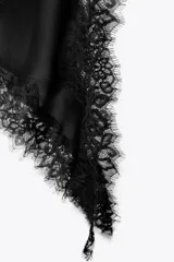 Vestido corto de satén con escote en pico y tirantes finos. Presenta aplicaciones de encaje en el escote y en el bajo, con un diseño asimétrico y abertura lateral.