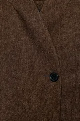 Blazer marrón de la colección Zara Woman, confeccionada en hilatura con 38% lana. Presenta cuello subido, manga larga con abertura y botones, bolsillos con solapa en el delantero y forro interior. Cierre frontal con un botón.