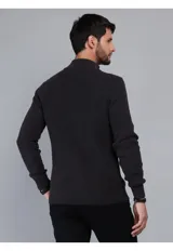Sweater de punto en color beige, con cuello alto y cierre frontal parcial. Diseño de manga larga con puños y ruedo acanalados.