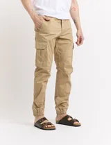 Pantalón de gabardina verde militar, corte cargo con bolsillos laterales con fuelle y tobillos ajustados con elástico.