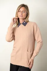 Sweater gris de punto con cuello redondo y mangas largas. Presenta diseño trenzado en el frente y dos bolsillos delanteros.