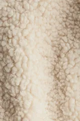 Chaleco de tejido sherpa color crema, con cuello alto, cierre frontal y bolsillos parche delanteros.