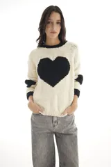 Sweater de lana merino color blanco marfil con un gran corazón negro en el frente, cuello redondo y mangas largas con puños acanalados negros.