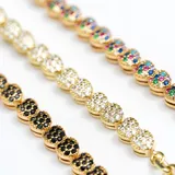 Pulsera dorada de eslabones con corazones cubiertos de cristales negros.