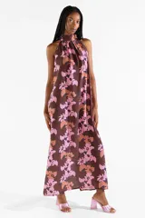 Vestido largo halter con estampado floral en tonos marrones y rosados, de diseño fluido sin mangas y cuello alto.