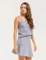 Musculosa de lino a rayas verticales azules y blancas, con breteles anchos y ruedo con flecos.