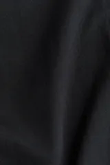 Remera negra de corte holgado, con cuello redondo y hombros caídos.