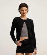 Cardigan de punto color negro, con cuello redondo, cierre frontal abotonado y mangas largas. Confeccionado en una mezcla de viscosa, poliéster y poliamida.